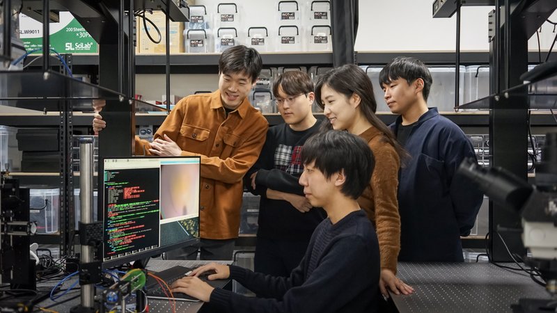 Prof. Lee and students at an optical setup